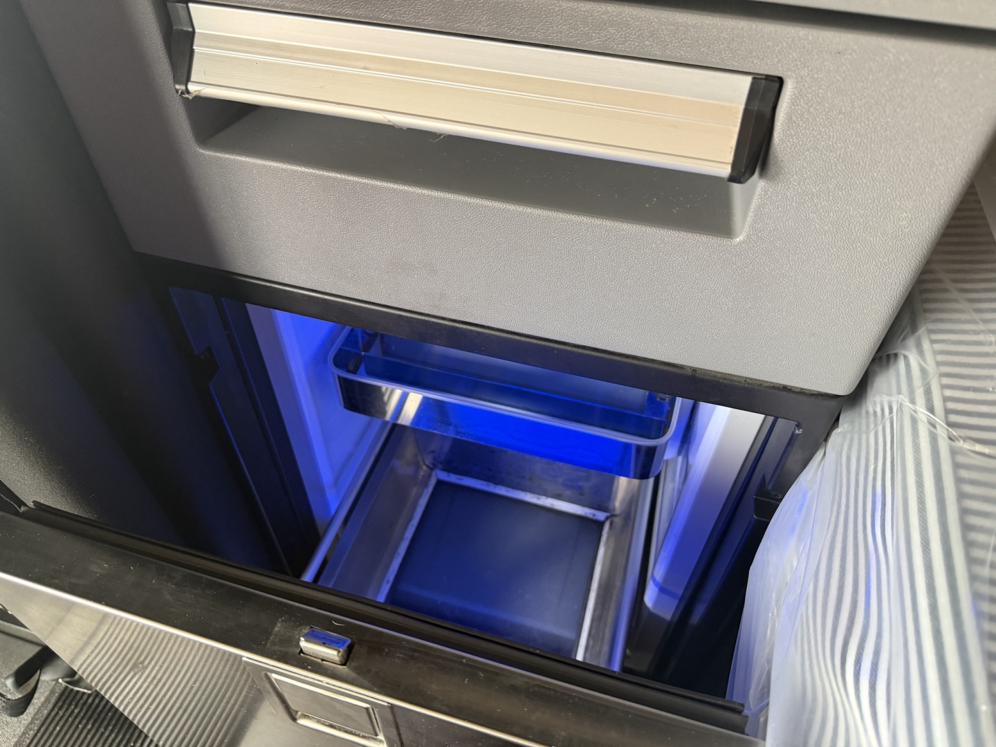 Cab display showing interior storage drawer and illuminated blue light in a Mack AN64T70 sleeper truck cabinet.