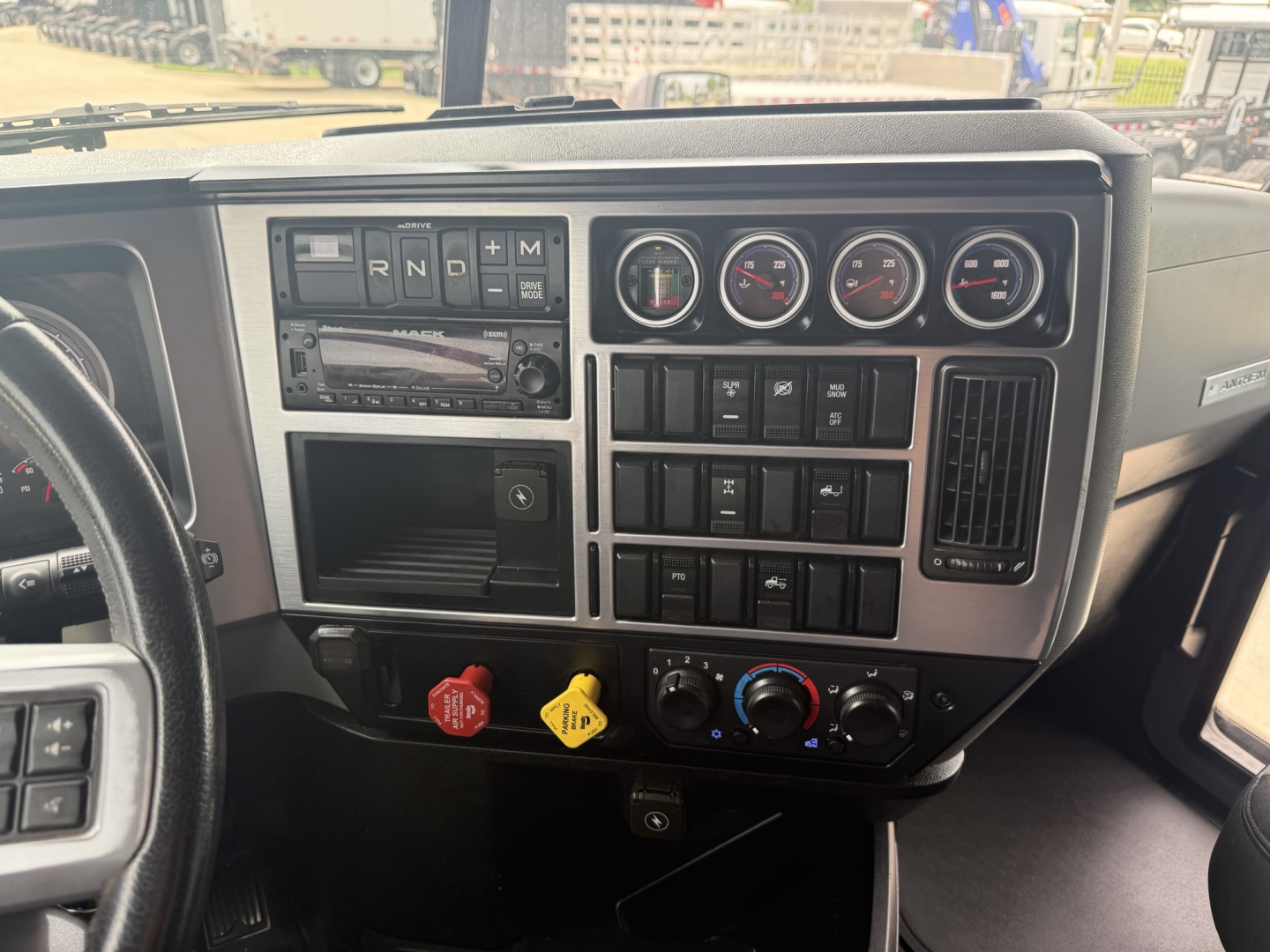 Dashboard of a Mack AN64T70 showing control panel with gauges, switches, and ignition area.