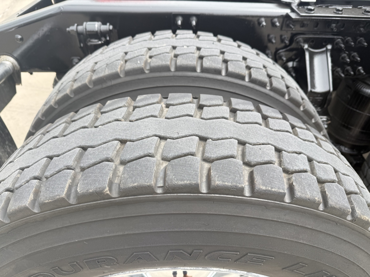 Tire and rear axle area of 2023 Mack AN64T70 sleeper truck showing dual rear tires and wheel assembly.