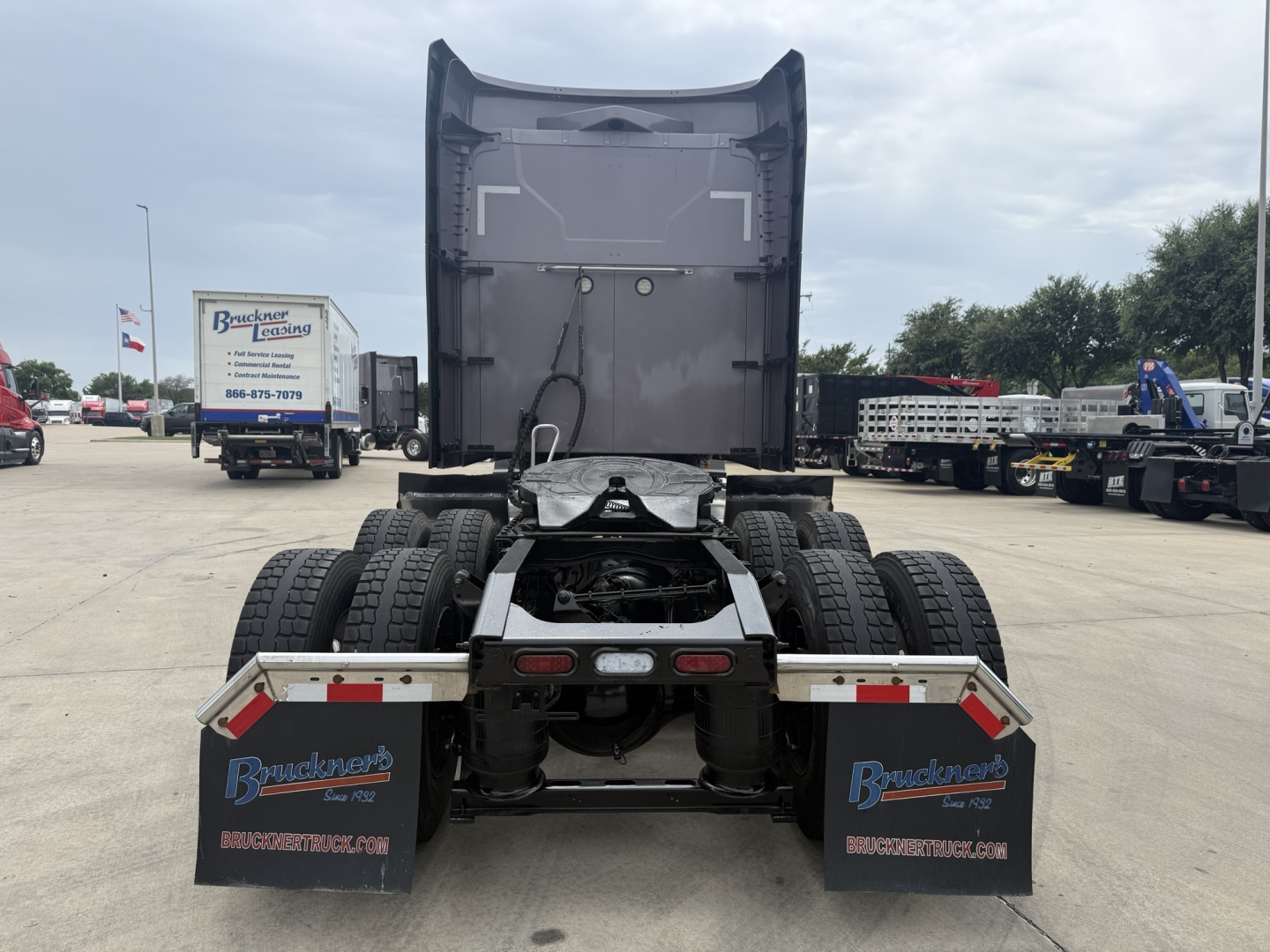 Truck rear view of a 2023 Mack AN64T70 conventional sleeper showing dual rear axles, fifth-wheel area, and mud flaps with Bruckner's signage.