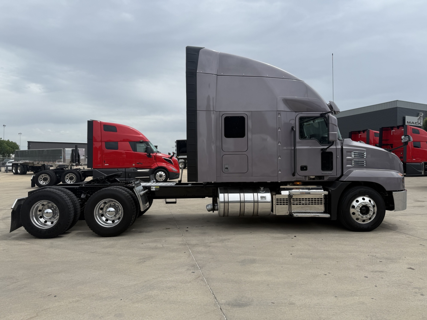 Side view of a gray Mack AN64T70 truck tractor showing sleeper cab and dual rear axles.
