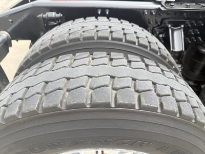 Tire and rear axle area of 2023 Mack AN64T70 sleeper truck showing dual rear tires and wheel assembly.
