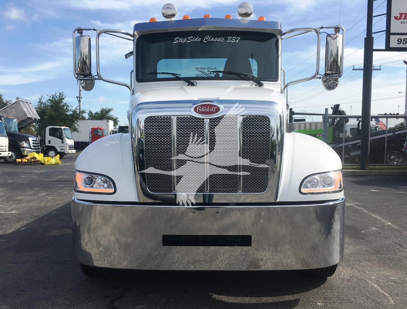 Peterbilt 337 rollback truck front view showing chrome grille, large bumper, and Peterbilt emblem.