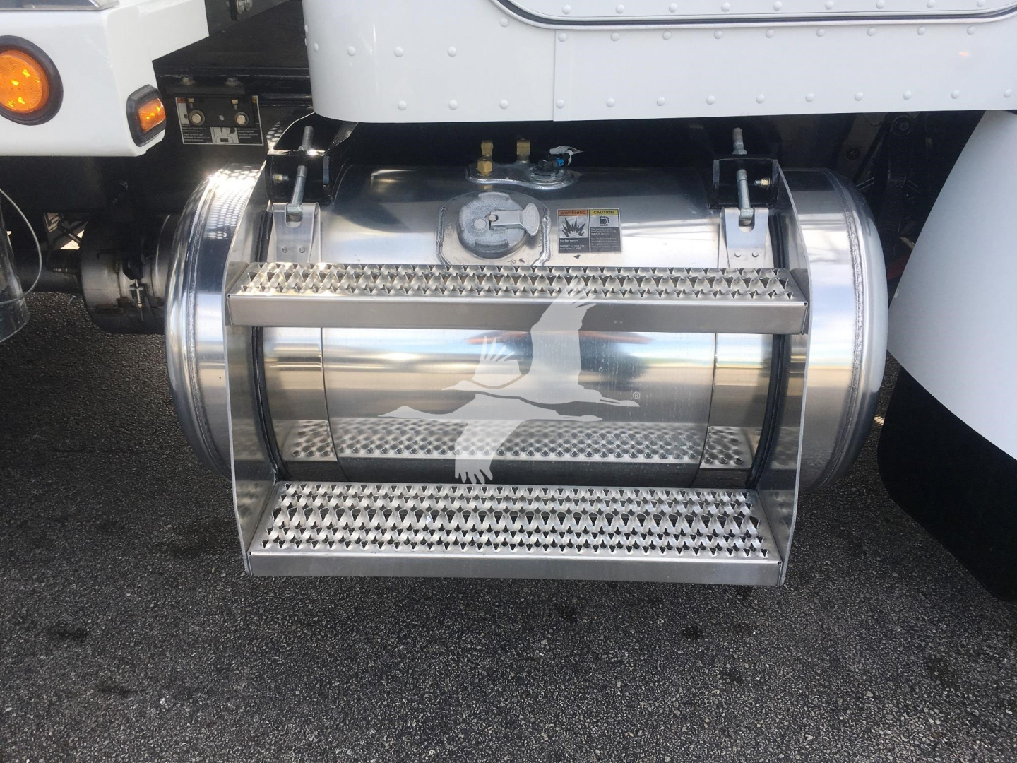 Peterbilt 337 rollback truck fuel tank mounted under cab with polished chrome cylindrical tank and steps on both sides.