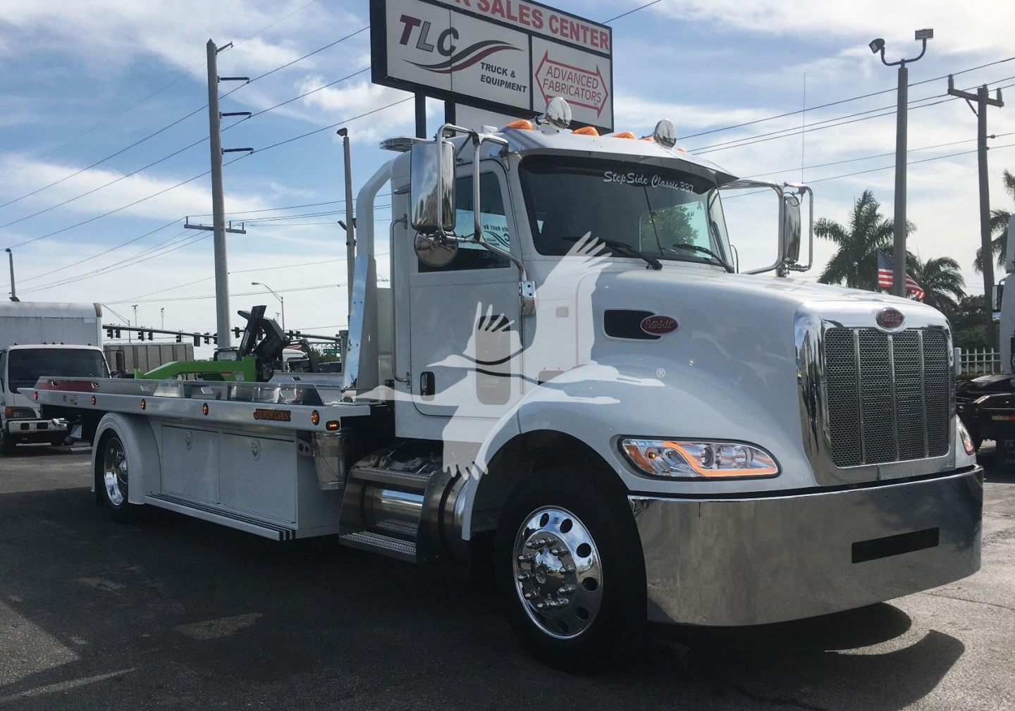  peterbilt 337 rollback truck showing chrome front bumper and extended bed with loading equipment