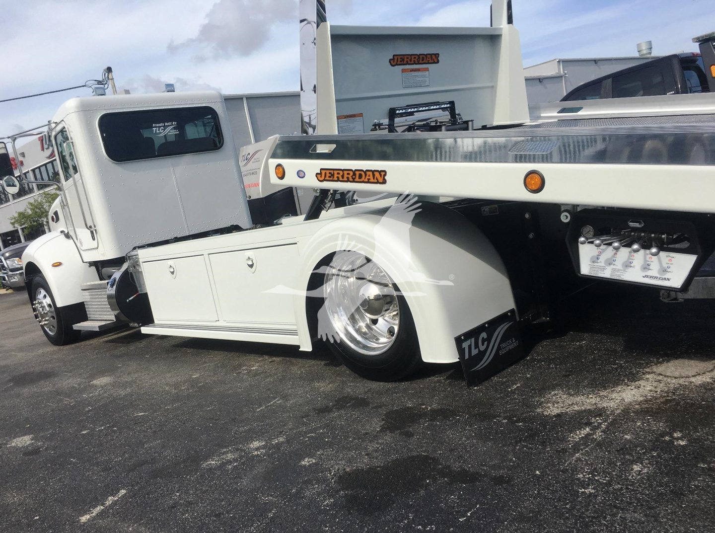 Peterbilt 337 rollback truck showing lowered front and side view with Jerr-Dan equipment and wheel covers.