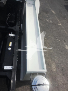 Truck bed side view showing empty toolbox bay and rear body of a 2022 Peterbilt 337 rollback truck.