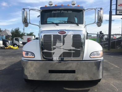 Peterbilt 337 rollback truck front view showing chrome grille, large bumper, and Peterbilt emblem.