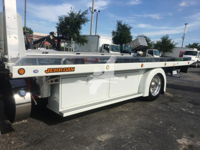 Peterbilt rollback truck chassis showing JERR-DAN brand on steel platform with storage compartments and wheel, side view.
