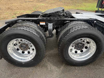 Truck chassis showing dual rear wheels and suspension components of a Freightliner Cascadia126 in-service, with chrome rims and tires visible.