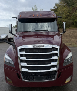 Freightliner Cascadia 126 front view showing bold chrome grille and maroon cab paint.