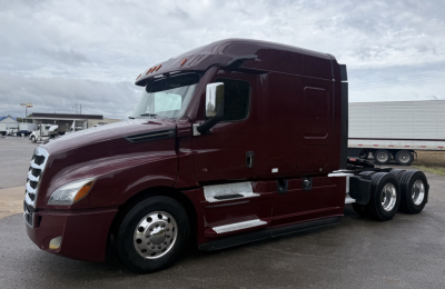 Freightliner Cascadia 126 truck tractor side view showing maroon exterior, dual rear wheels, chrome steps and mirrors.