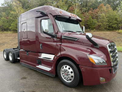 Cascadia126 semi truck tractor in maroon showing side profile with sleeper cab, chrome steps, and rear axles. Visible text not legible.