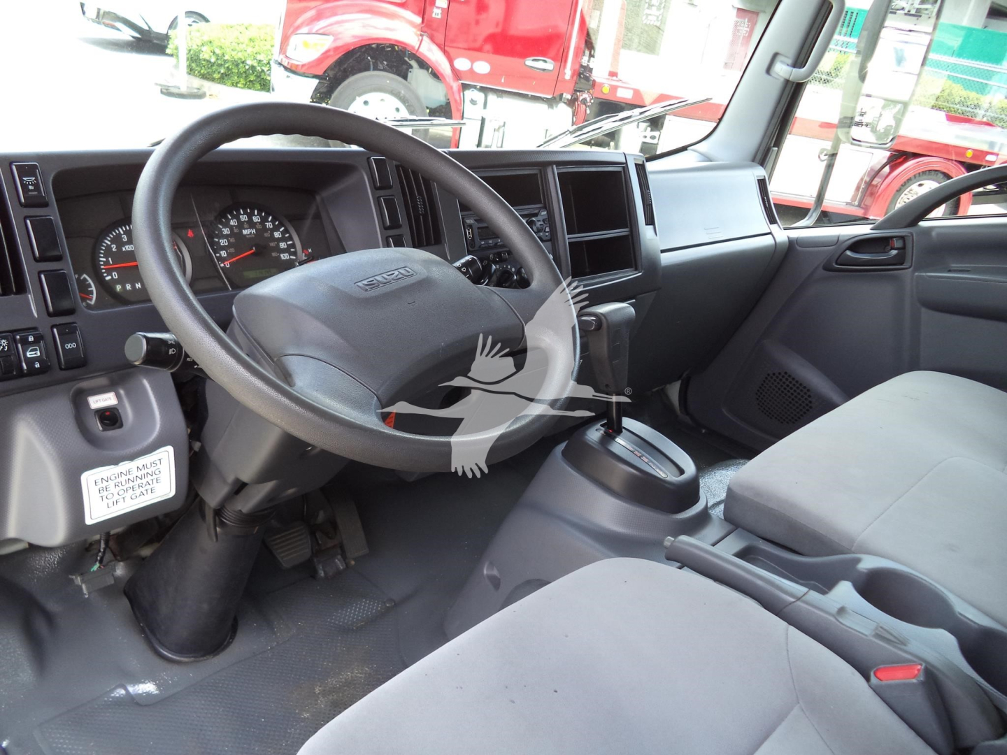 Isuzu NPR HD cab interior showing steering wheel, dashboard, and seating area
