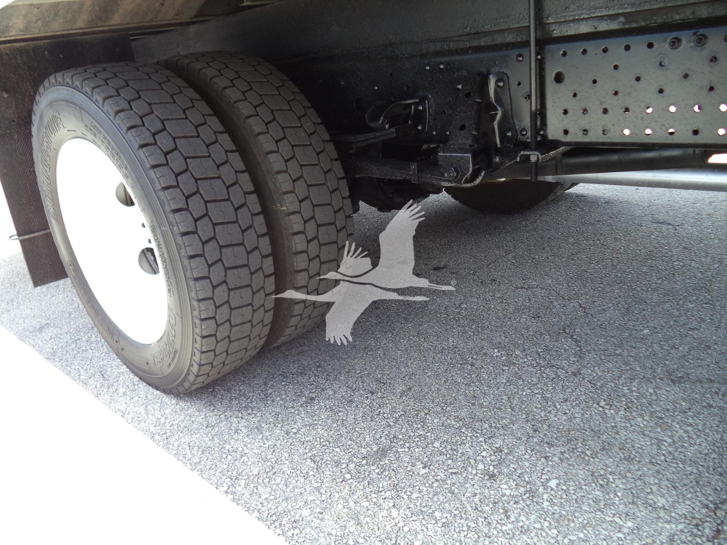 Isuzu NPR-HD truck rear wheel and chassis showing dual rear tires and undercarriage components.