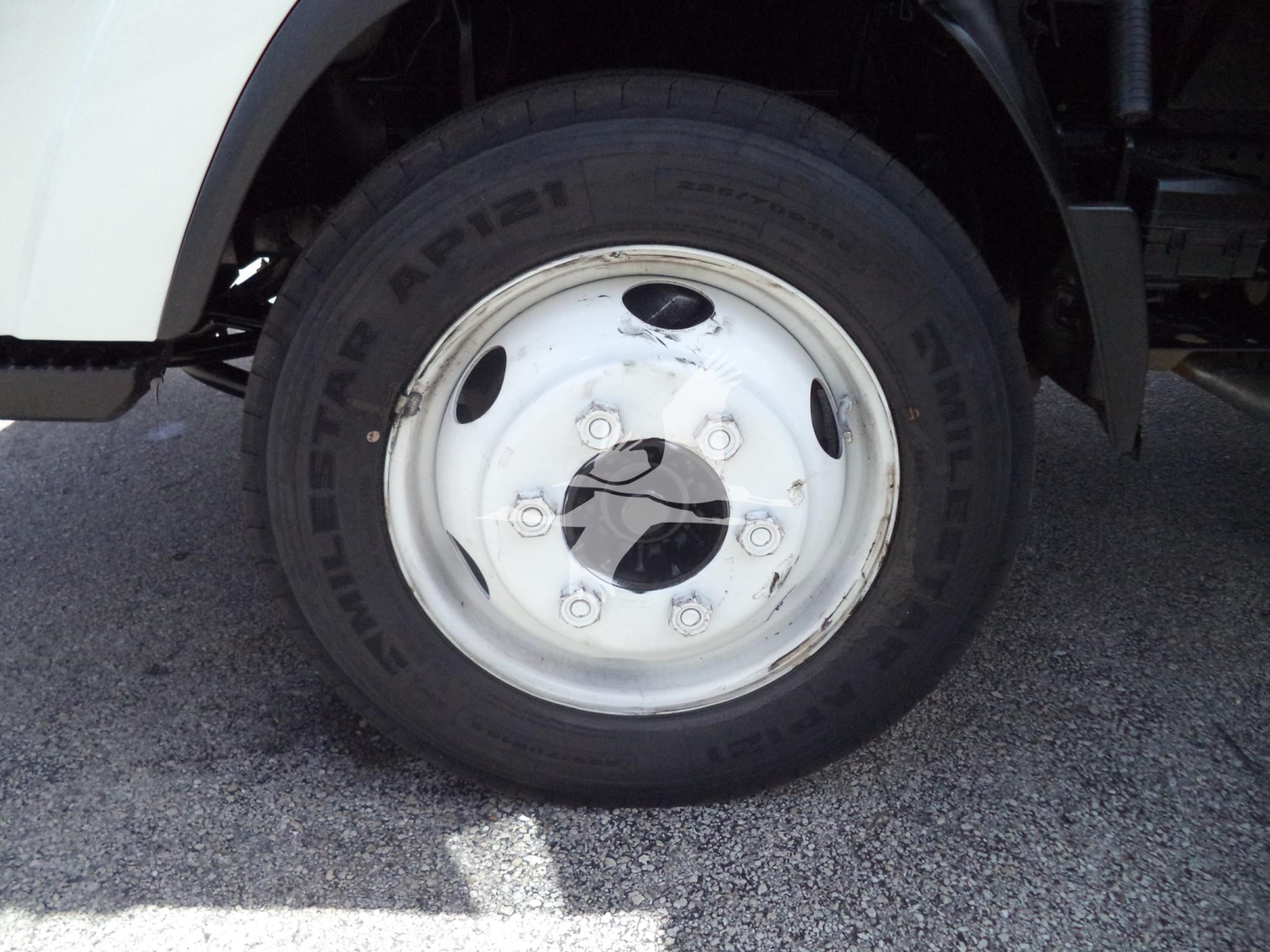 Isuzu NPR HD wheel and tire showing 225/70R19.5 tire on white steel rim, front fender and part of chassis visible.