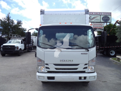 Isuzu NPR HD truck front view in a dealership lot showing Isuzu grille and windshield, with Péngske banner on truck cab.