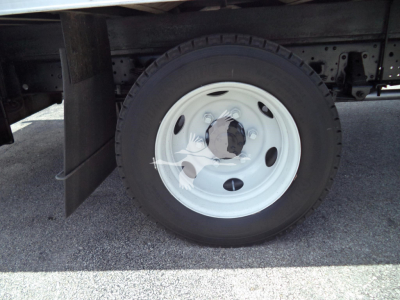 Isuzu NPR HD truck wheel and tire showing white steel rim and black tire under truck bed.