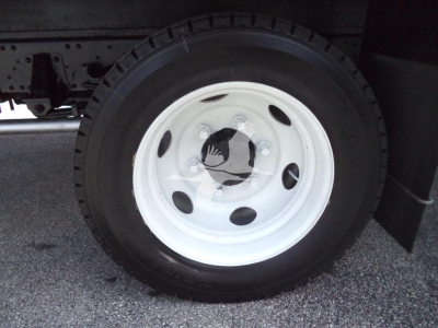 Isuzu NPR HD truck wheel and tire with white steel rim and black tire. Visible round hub with center cap and lug nuts.