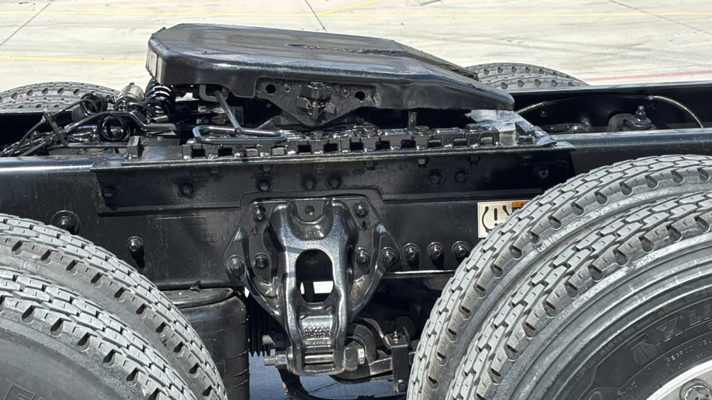 Kenworth T680 truck chassis view showing rear frame and dual rear tandem suspension, with air cab mounts and fuel/air lines; visible tires and frame members.