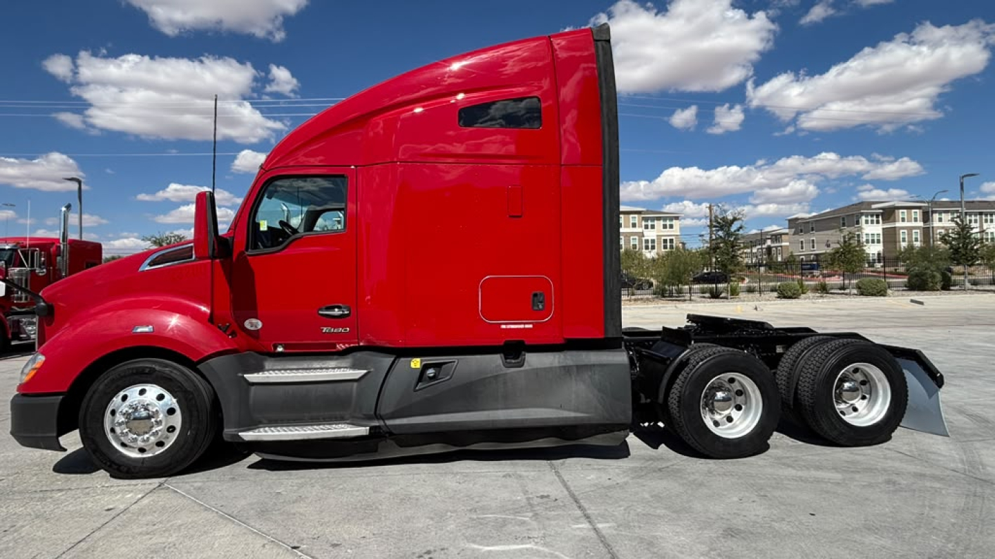 Kenworth T680 tractor side profile showing red cab, two rear axles, fuel tanks, and chrome wheels.