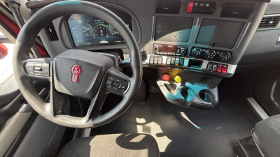 Kenworth truck cabin dashboard and steering wheel with controls and switches visible