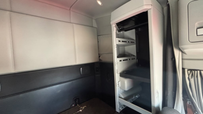 Kenworth T680 truck cab interior showing an open refrigerator/freezer unit with shelves inside cargo area.