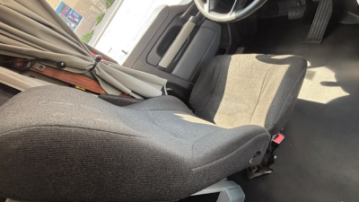 Cab interior of a 2022 Kenworth T680 with driver seat, steering wheel, and partial dashboard visible.