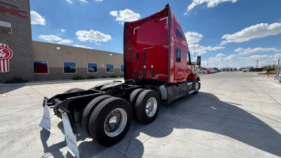 Kenworth T680 tractor in red color, side view showing chassis and rear axles, no trailer attached, clear sky