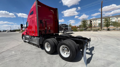 Kenworth T680 tractor with red sleeper cab, rear view shows dual rear axles and fifth wheel hitch, no trailer attached.