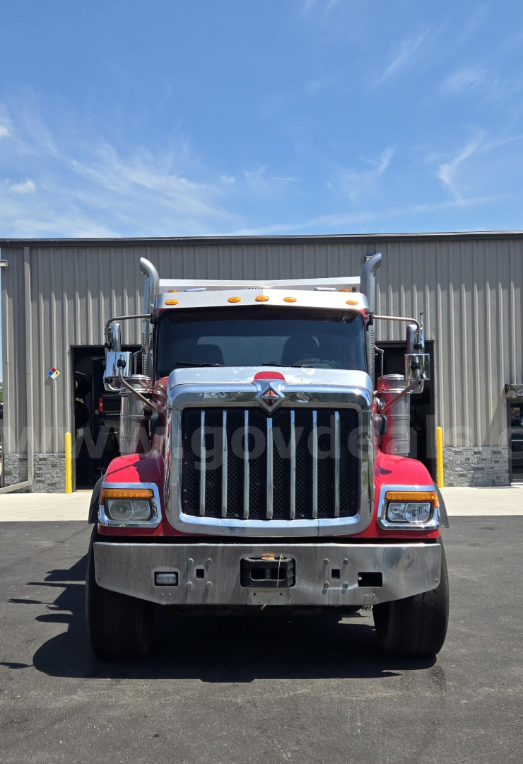 Front view of a red and white 2018 International HX dump truck showing bold chrome grille and bumper.