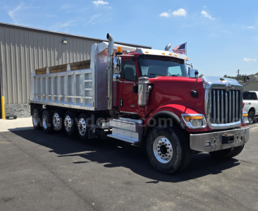 Dump truck 2018 International HX side view showing red cab and silver dump body.