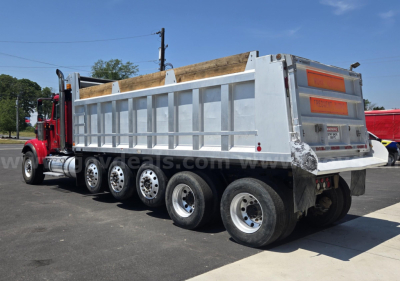 Dump truck (2018 International HX) side view showing multi-axle rear with dump bed and tailgate, stock number 29174-84.