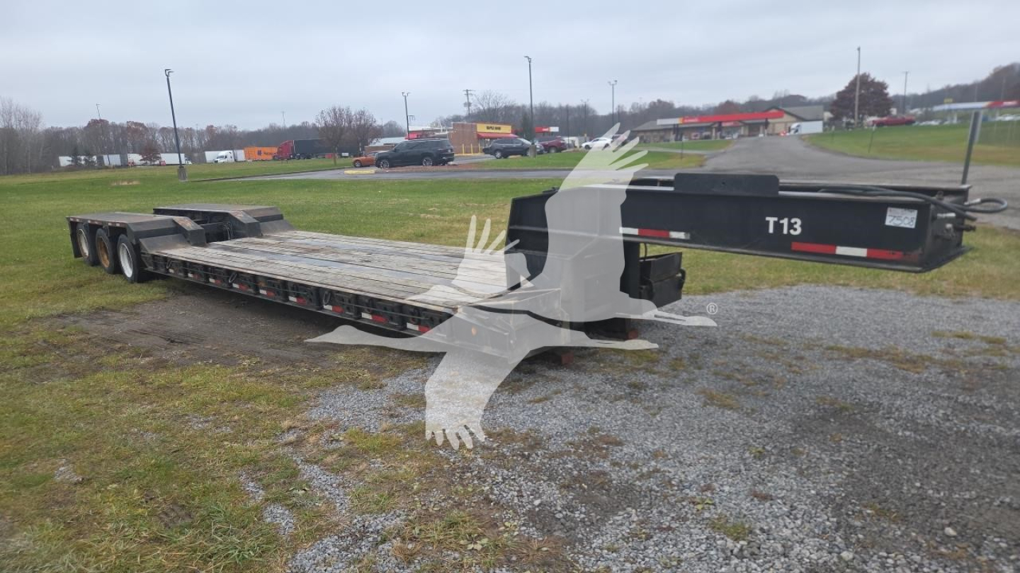 Logistics trailer: Rogers lowboy flatbed with multiple axles, long steel deck, black rear with 'T13' marking, stock: 7508, VIN partially visible.