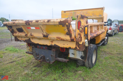 Dump truck bed and rear view of a 2011 Ford F350 Super Duty dump truck showing yellow bed with rusted edges and tailgate, dual rear wheels, and hitch area.