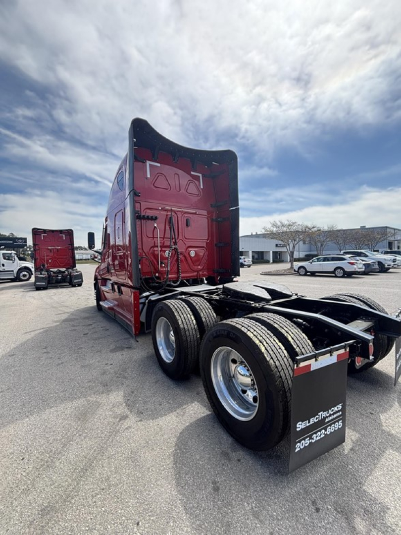 Freightliner Cascadia 126 tractor rear view showing dual rear axles, red cab, and trailer hitch in a truck lot.