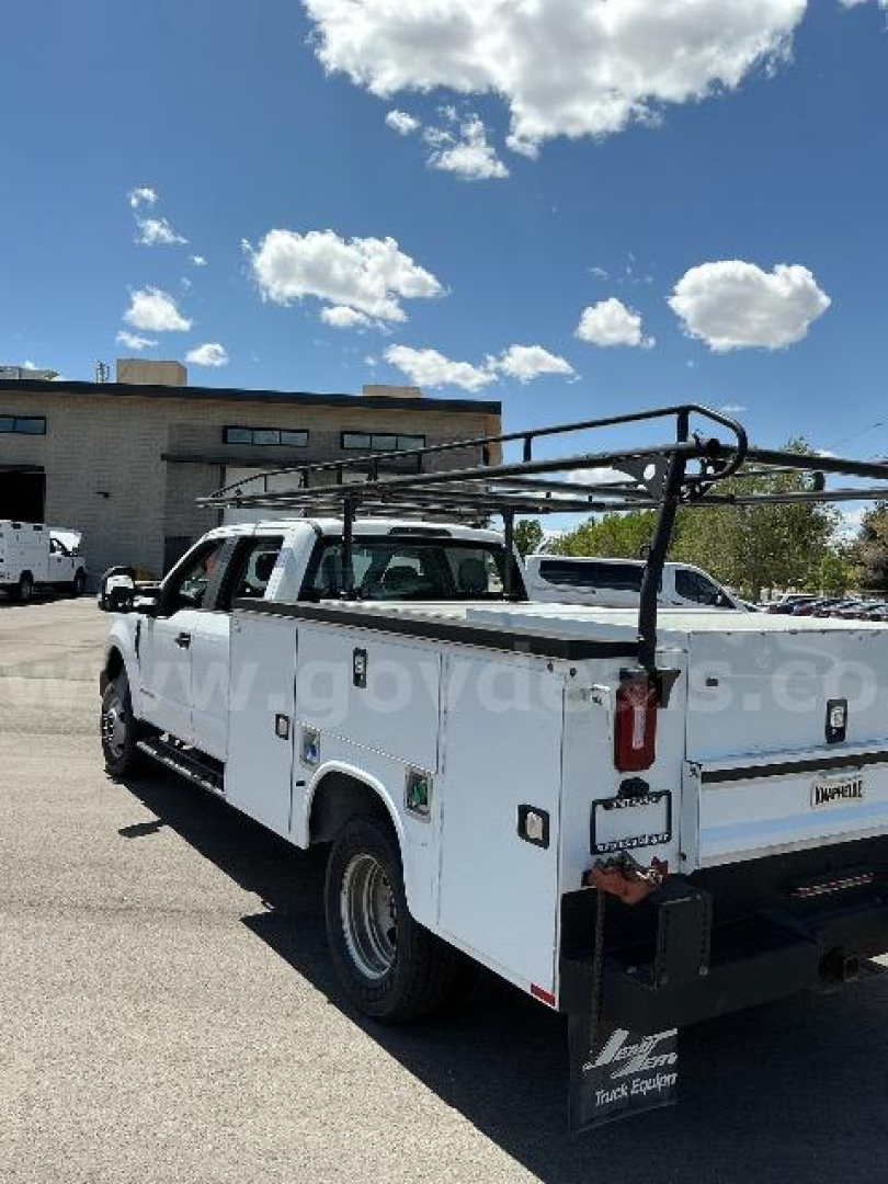 Ford F-350 utility truck with utility bed and ladder rack, white, rear view showing tailgate and bumper