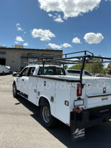 Ford F-350 utility truck with utility bed and ladder rack, white, rear view showing tailgate and bumper