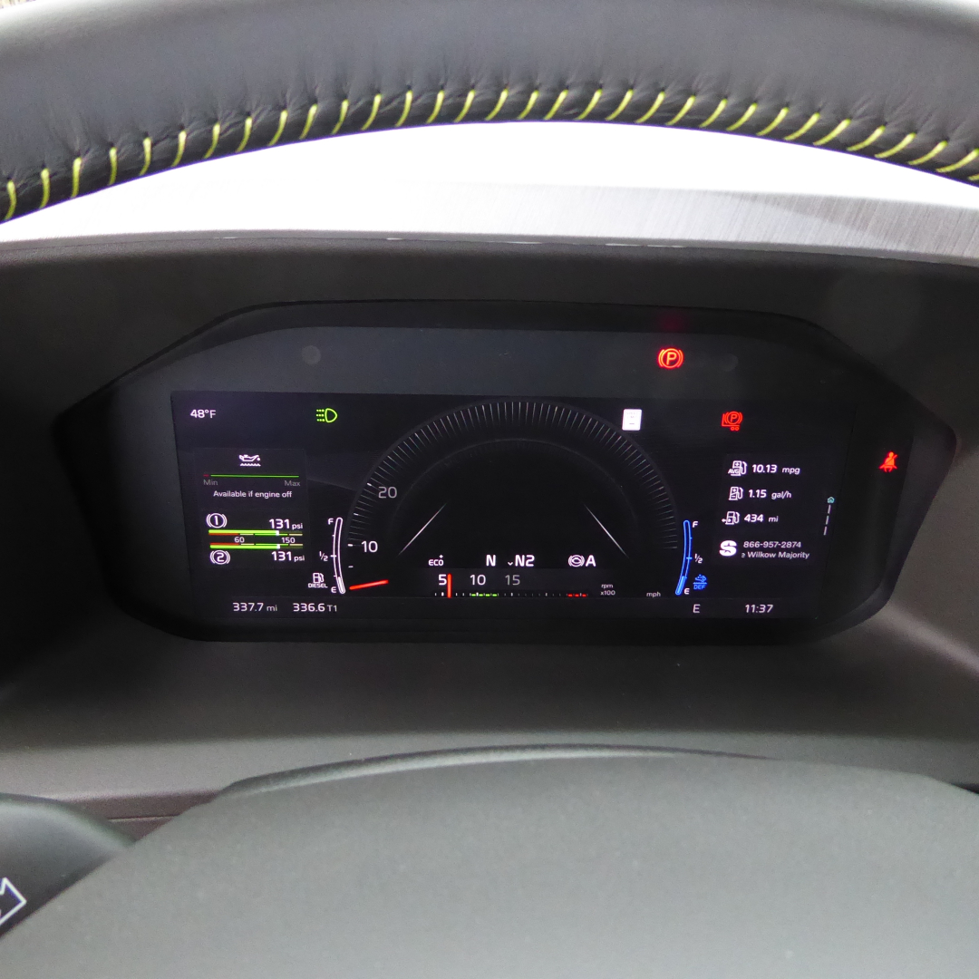 Volvo VNL dashboard and steering wheel with digital gauge cluster in view showing instrument panel and small status icons.