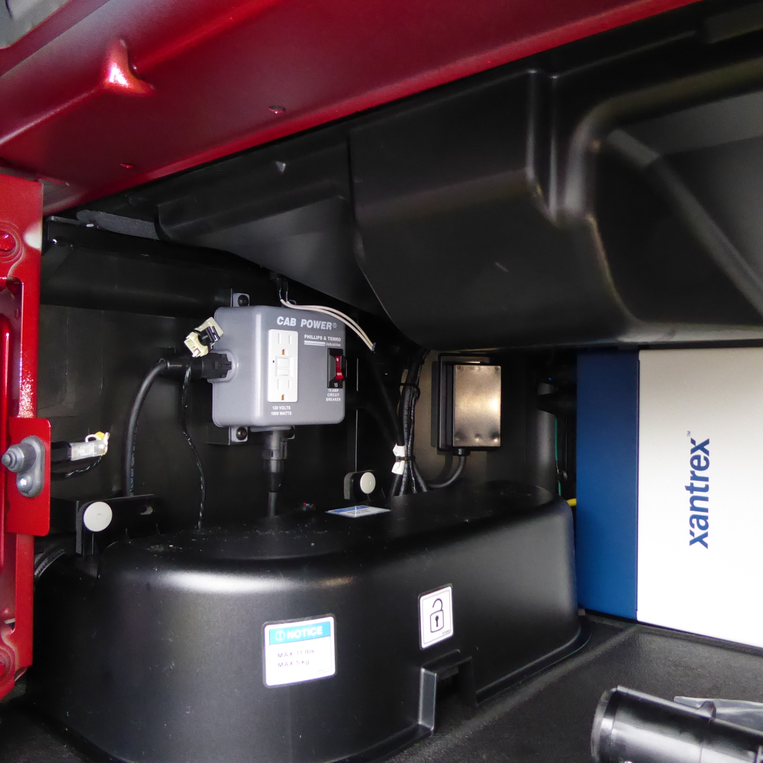 Trucks engine bay showing cab power inverter and Xantrex box with blue/white panel visible.
