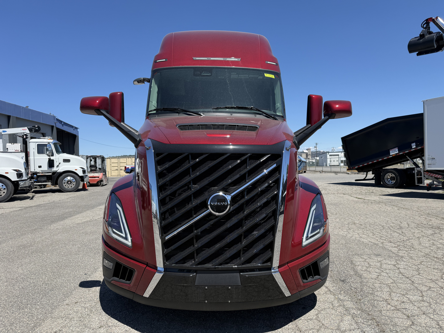 Front view of a red Volvo VNL64T860 truck showing grille, headlights, and side mirrors.