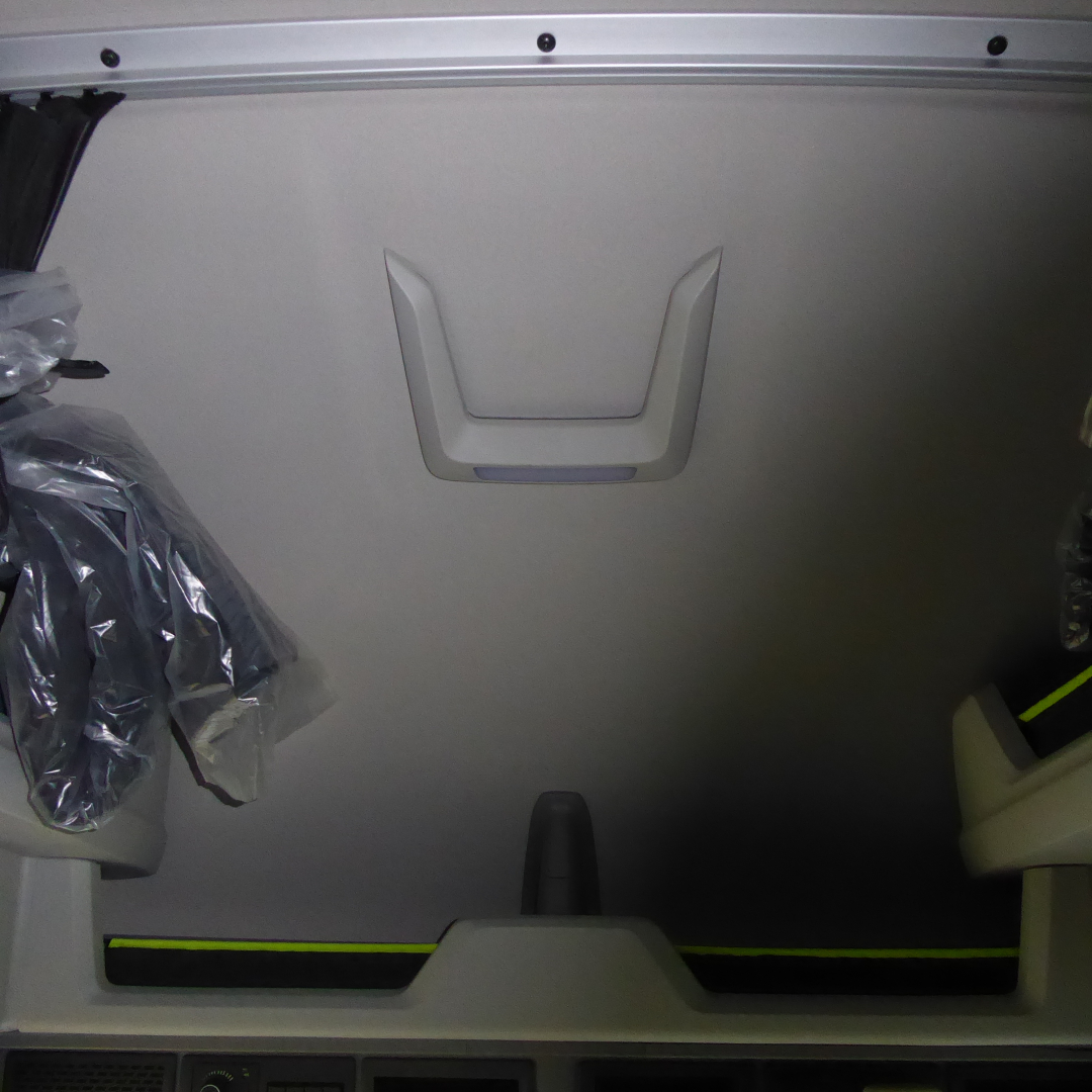 Volvo VNL64T860 sleeper cab interior cargo area with unrolled seat/cover visible and a recessed handle on a metal panel.