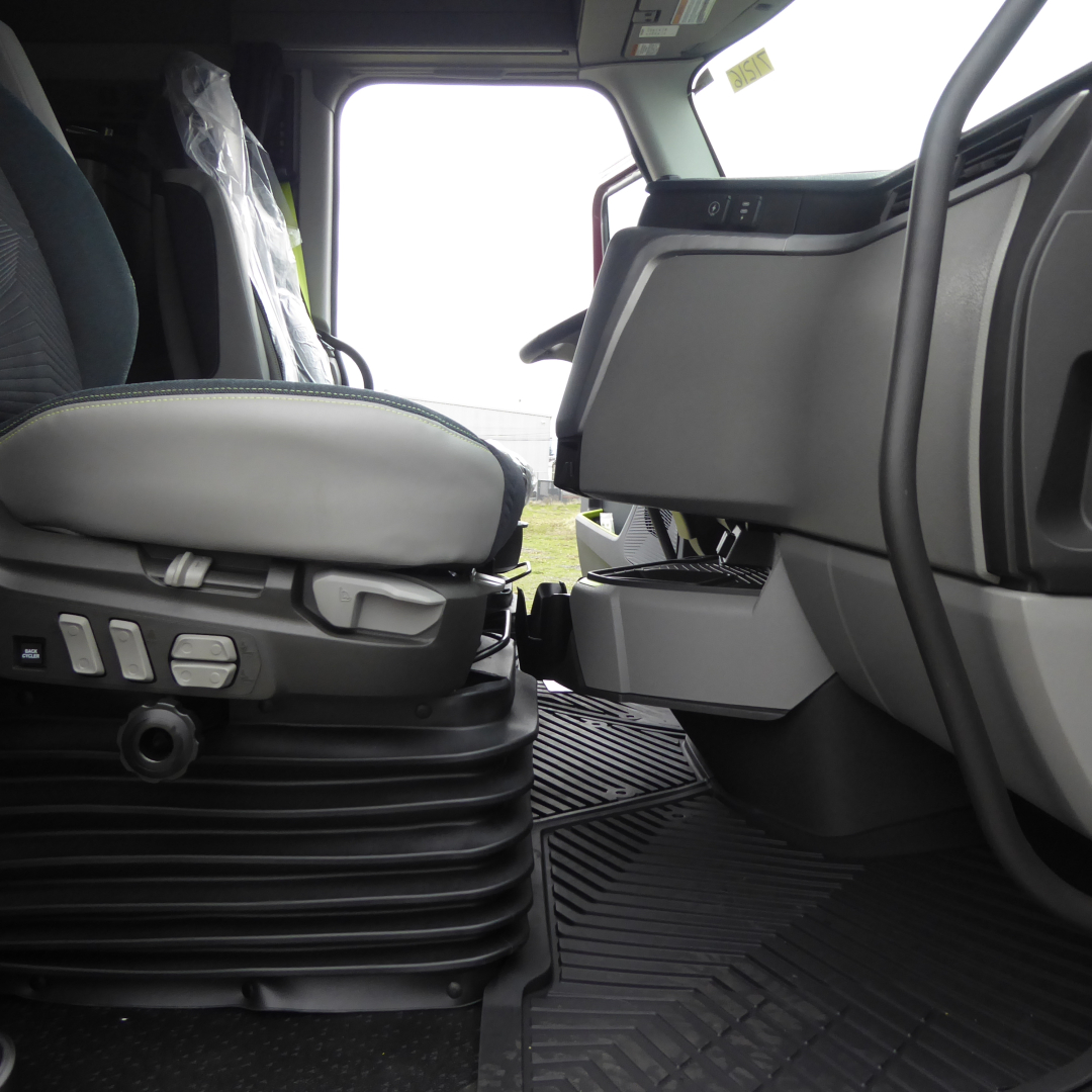 Volvo VNL64T860 truck interior showing driver seat controls and entry floor mat.