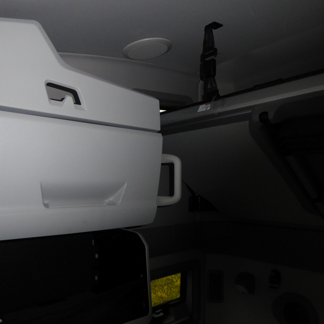 Interior bunk area of a 2026 Volvo VNL64T860 sleeper cab showing overhead storage and seatbelt hardware.