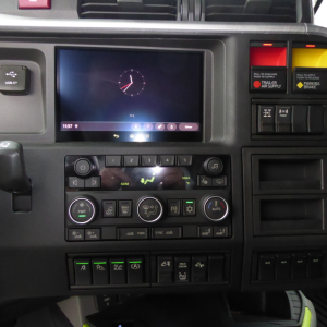 Dashboard of a Volvo VNL truck showing a center touchscreen display and climate controls; visible labels include USB-C port, climate control icons, and various status buttons.