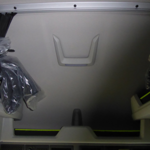 Volvo VNL64T860 sleeper cab interior cargo area with unrolled seat/cover visible and a recessed handle on a metal panel.