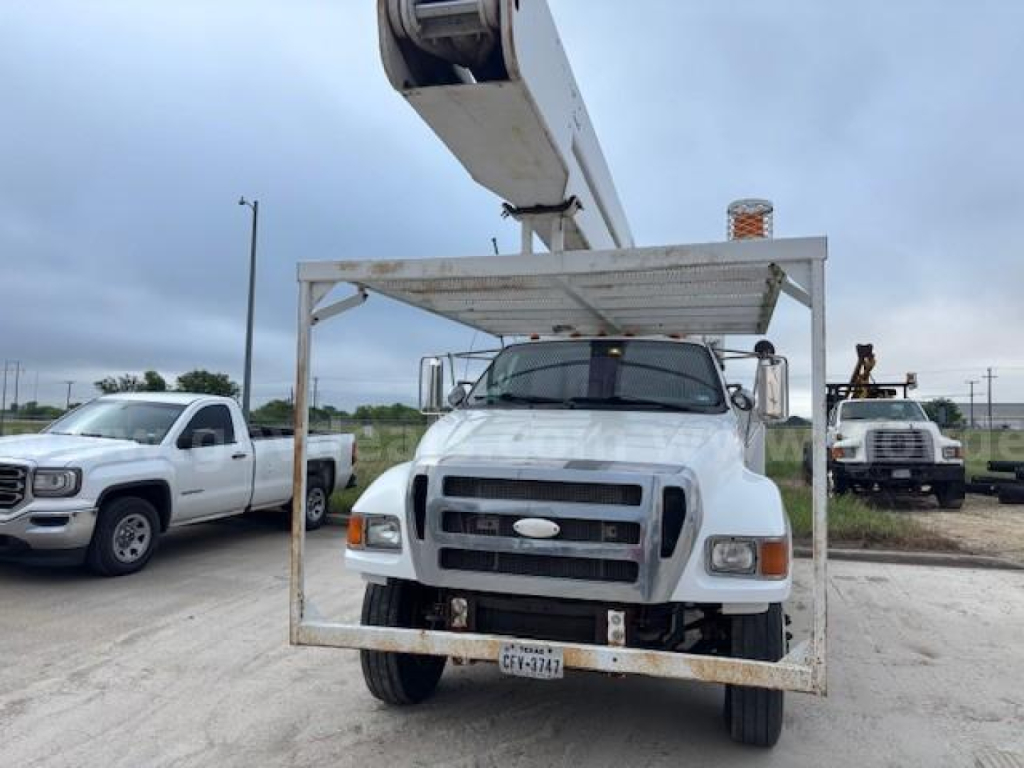 Truck bucket lift mounted on Ford F-750 with front grille and license plate visible.
