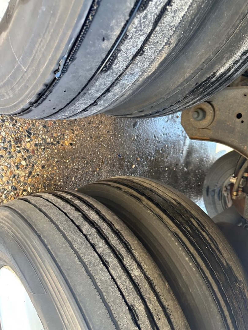 Trailer dual wheels with tread and suspension components visible; close-up of tires and wheel area on a Wabash dry van trailer.