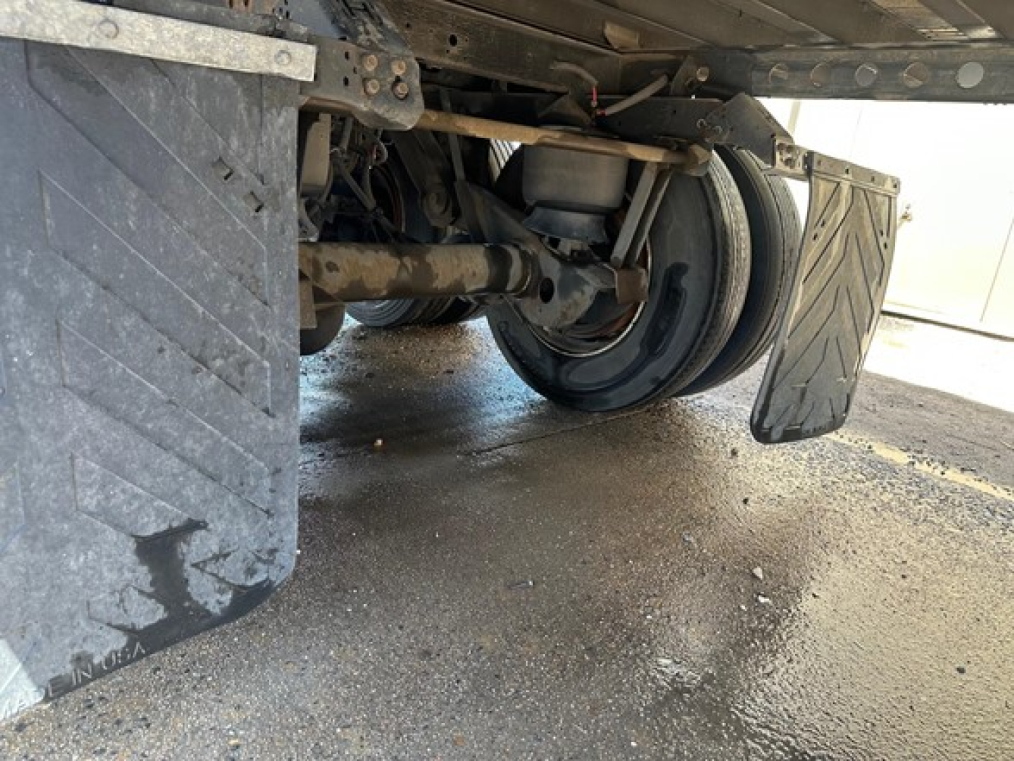 Underbelly view of 2024 Wabash Duraplate Dry Van trailer showing suspension, wheels, and mud flaps.