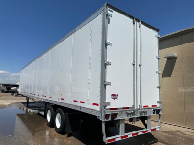 Rear and side view of a white 2024 Wabash Duraplate dry van trailer showing double doors with hinge latches and red and white reflective strips.